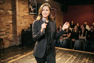 Humoriste française sur scène dans un comedy club parisien, micro en main, expression expressive et assurée